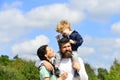 Happy family - mother, father and son on sky background in summer. Happy child playing with toy paper plane against Royalty Free Stock Photo