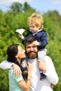 Happy family - mother, father and son on sky background in summer. Happy child playing with toy paper plane against Royalty Free Stock Photo