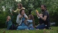 Happy family mother Father Three four Baby little siblings kids have fun blowing bubbles enjoying summer holidays in Royalty Free Stock Photo