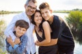 happy family, mother, father and two cheerful children hugging in nature Royalty Free Stock Photo