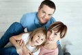 Happy family mother, father and two children playing and cuddling at home on floor. Unusually view from above. Royalty Free Stock Photo