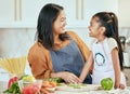 Happy family, mother girl cooking food for a healthy vegan diet with spaghetti and vegetables at home. Smile