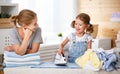 Happy family mother housewife and child daughter ironing clothes Royalty Free Stock Photo