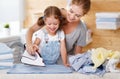 Happy family mother housewife and child daughter ironing clothes Royalty Free Stock Photo