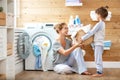 Happy family mother housewife and child in laundry with washin Royalty Free Stock Photo