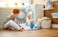 Happy family mother housewife and children in laundry load a washing machine