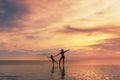 Happy Family. Mother And Kid Silhouettes. Mom And Daughter Posing On Sea Beach. Beautiful Sunset Sky And People Reflection. Royalty Free Stock Photo