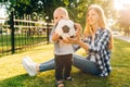 Happy family, Mother and little child are having fun sitting on green grass Royalty Free Stock Photo