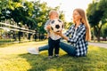 Happy family, Mother and little child are having fun sitting on green grass Royalty Free Stock Photo