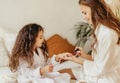 Happy family mother and little daughter in bathrobe makes manicure, laugh  on Spa day at home Royalty Free Stock Photo