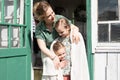 Happy family mother with little kids daughters helper girls have fun in suburb countryside life on laundry day. candid mom hug and