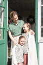 Happy family mother with little kids daughters helper girls have fun in suburb countryside life on laundry day. candid mom hug and