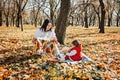 Happy family mother and little toddler baby daughter having fun together in autumn picnic Royalty Free Stock Photo
