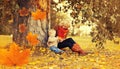 Happy family mother playing with child son in autumn park with yellow leaves Royalty Free Stock Photo