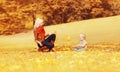 Happy family mother playing with child son in autumn park with yellow leaves Royalty Free Stock Photo