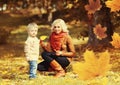 Happy family mother playing with child son in autumn park with yellow leaves Royalty Free Stock Photo