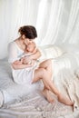 Happy family mother playing and hug with newborn baby in bed Royalty Free Stock Photo