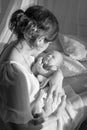 Happy family mother playing and hug with newborn baby in bed. Black and white Royalty Free Stock Photo