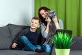 A happy family, mother, son and cat are sitting on the sofa feeling happy. Concept inferior family, no father, widow, modern woman Royalty Free Stock Photo