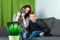 A happy family, mother, son and cat are sitting on the sofa feeling happy. Concept inferior family, no father, widow, modern woman Royalty Free Stock Photo