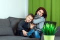 A happy family, mother, son and cat are sitting on the sofa feeling happy. Concept inferior family, no father, widow, modern woman Royalty Free Stock Photo