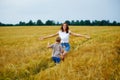 Happy family mother and son in a summer wheat field. The son runs to meet the mother, and she opens her arms for a hug Royalty Free Stock Photo