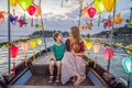 Happy family Mother and son of travelers ride a national boat on background of Hoi An ancient town, Vietnam. Vietnam