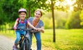 Happy family mother teaches child daughter to ride a bike in the Park Royalty Free Stock Photo