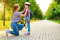 Happy family mother teaches child daughter to ride a bike in the Park Royalty Free Stock Photo