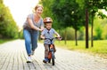 Happy family mother teaches child son to ride a bike in the Park Royalty Free Stock Photo