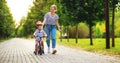 Happy family mother teaches child son to ride a bike in the Park Royalty Free Stock Photo