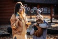 Happy family mother and teen boy son with cute cocker spaniel puppy blow soap bubbles outdoor in autumn park. Royalty Free Stock Photo