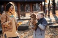 Happy family mother and teen boy son with cute cocker spaniel puppy blow soap bubbles outdoor in autumn park. Royalty Free Stock Photo