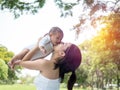 Happy family, Mother throws baby up playing and kissing with love in the summer in the park Royalty Free Stock Photo