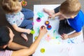 Happy family of mother and toddler twins are painting