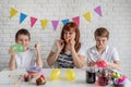 Happy family of mother and two boys blowing up the balloons