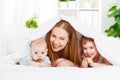 Happy family mother and two children, son and daughter in bed un Royalty Free Stock Photo