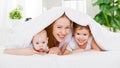 Happy family mother and two children, son and daughter in bed un Royalty Free Stock Photo