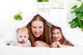 Happy family mother and two children, son and daughter in bed un Royalty Free Stock Photo