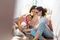 Happy family mother two daughters girls and poodle dog having fun together on bed in room at the home Royalty Free Stock Photo
