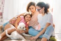 Happy family mother two daughters girls and poodle dog having fun together on bed in room at the home Royalty Free Stock Photo
