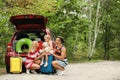 Happy family near car trunk with suitcases outdoors