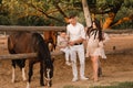 Happy family near horses at a farmer& x27;s ranch at sunset Royalty Free Stock Photo