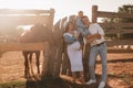 Happy family near horses at a farmer's ranch at sunset Royalty Free Stock Photo