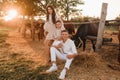 Happy family near horses at a farmer's ranch at sunset Royalty Free Stock Photo