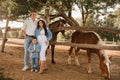 Happy family near horses at a farmer& x27;s ranch at sunset Royalty Free Stock Photo