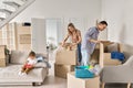 Happy family new home owners with child unpacking cardboard boxes on moving day. Royalty Free Stock Photo