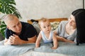 Happy family with newborn baby on the bed in the room Royalty Free Stock Photo