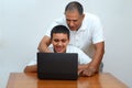 Happy family old grandfather and grandson on laptop.Elderly teacher trainer and teen pupil boy. Royalty Free Stock Photo