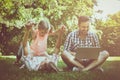 Happy family with one child in nature. Father sitting on grass a Royalty Free Stock Photo